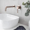 BASIN MIXERS Bathroom setup with a white sink, bronze faucet, and circular mirror.