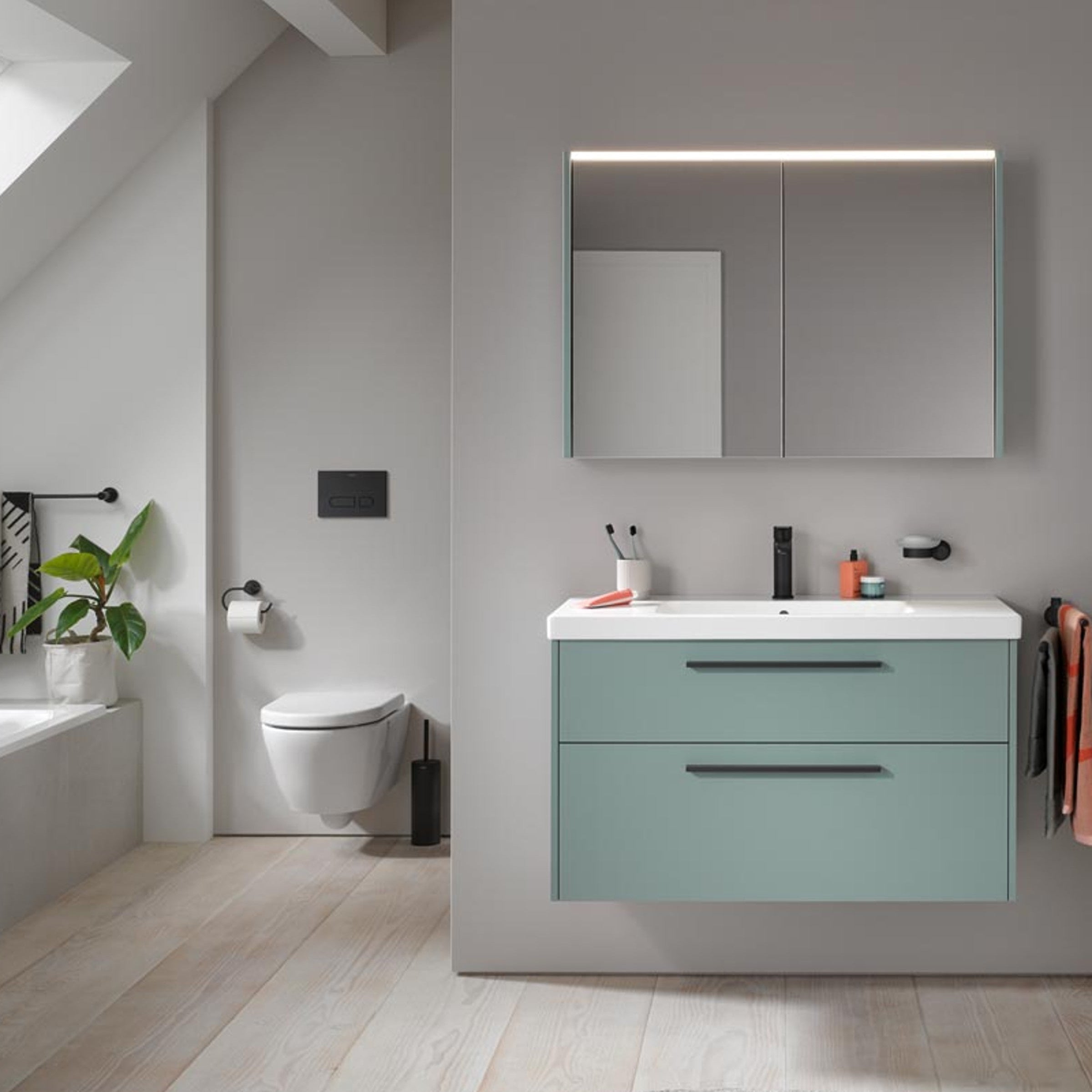 Wall-hung two-drawer vanity unit with integrated basin, mirror cabinet and wall-hung toilet in a modern bathroom