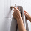 Hand hanging a towel on a Meir bathroom towel hook