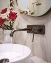 Blutide gunmetal wall-mounted basin mixer over a white countertop basin