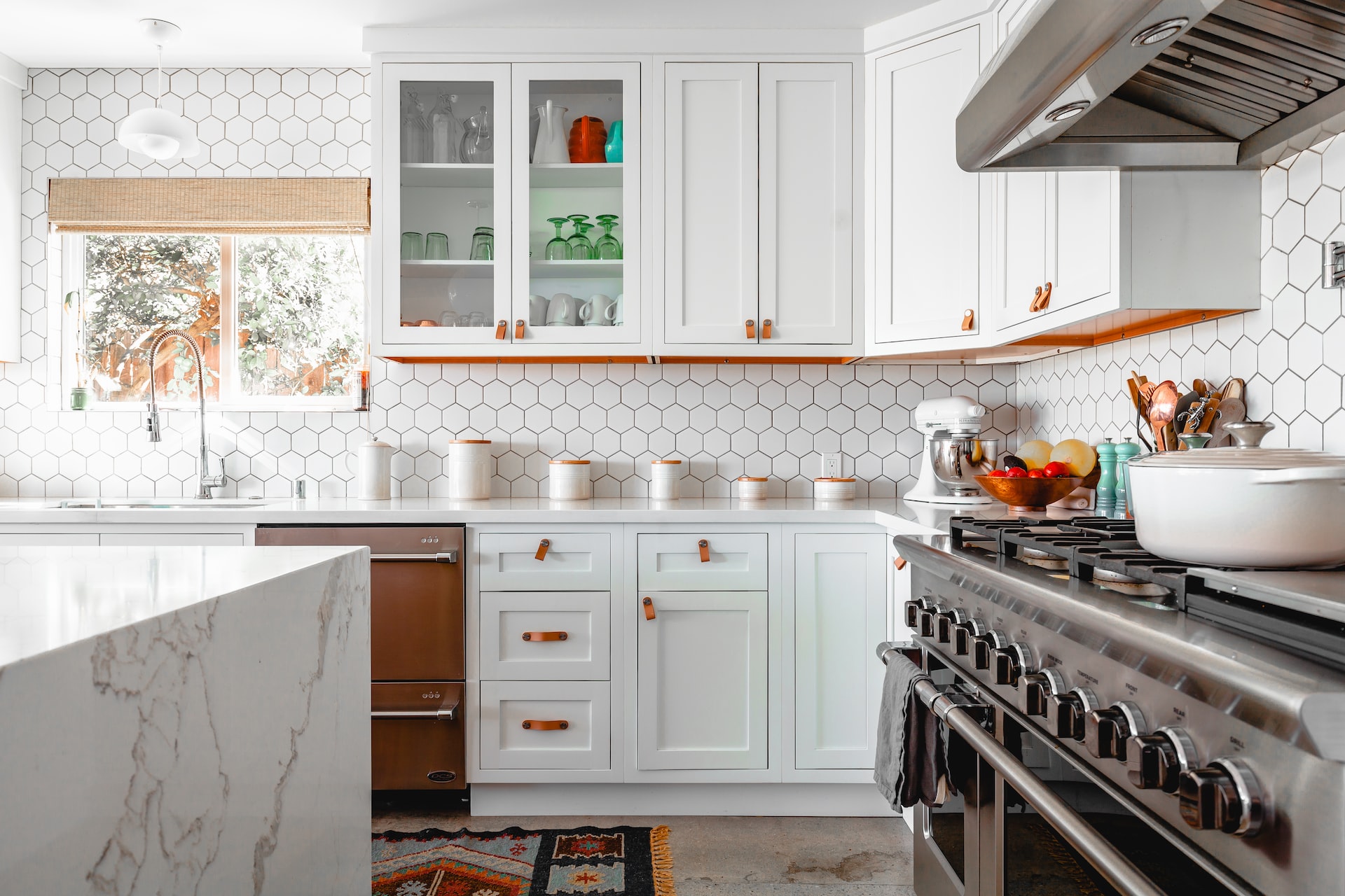 A kitchen that has incorporated marble and hexagon tiles into its design